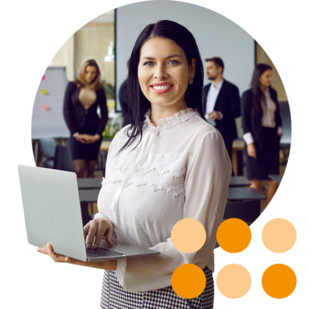 Image of a business person stood in a training room with a laptop