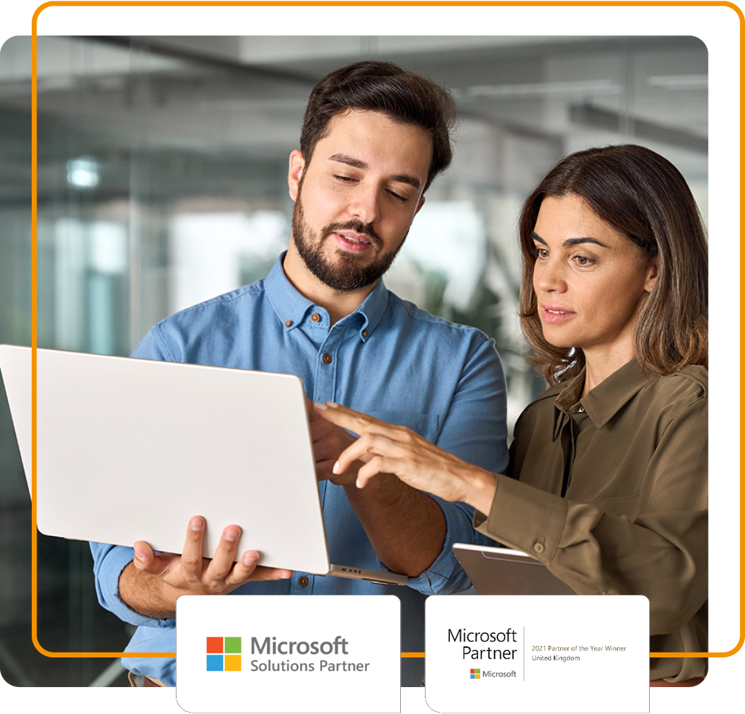 Image of two colleagues stood with a laptop in an office environment with our Microsoft Solution Partner and Microsoft 2021 UK Partner of the Year logos