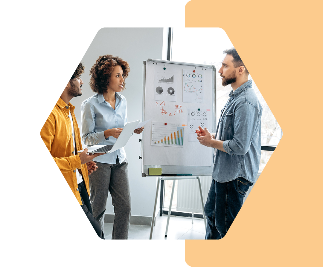 Image of a group of coworkers working around a whiteboard