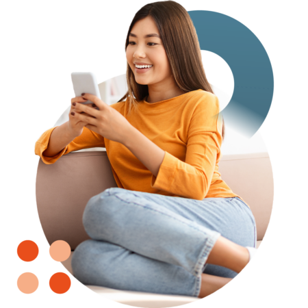 Image of a smiling person sat on a sofa using a chatbot on their mobile phone