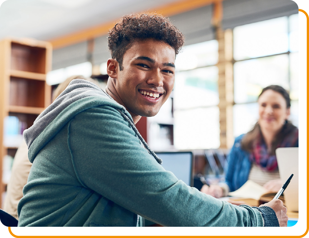 Image of a smiling student sat in a school library