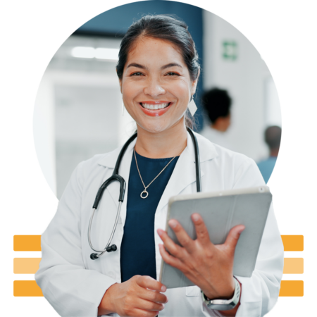 Image of a smiling doctor holding a tablet in a hospital