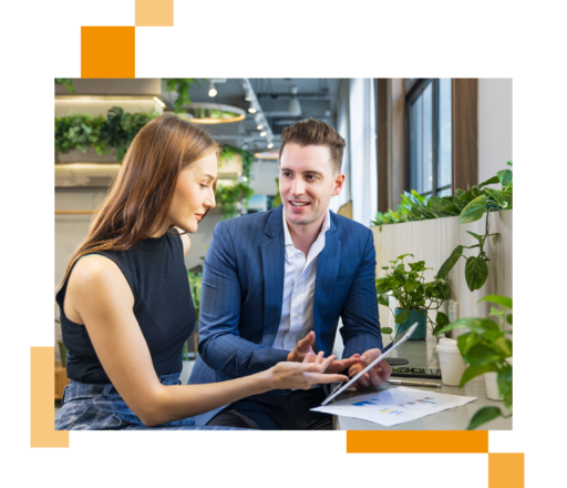 Image of two business professionals sat in an office working on a tablet