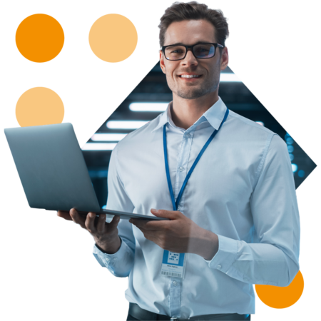 Image of an IT engineer stood in a server room holding a laptop