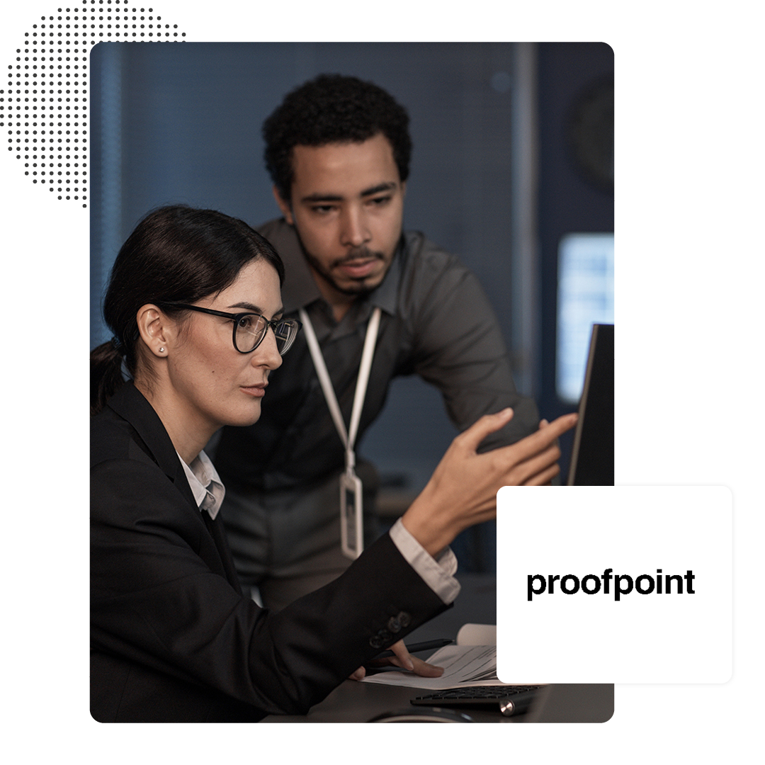 Two people working on a computer with a ProofPoint logo