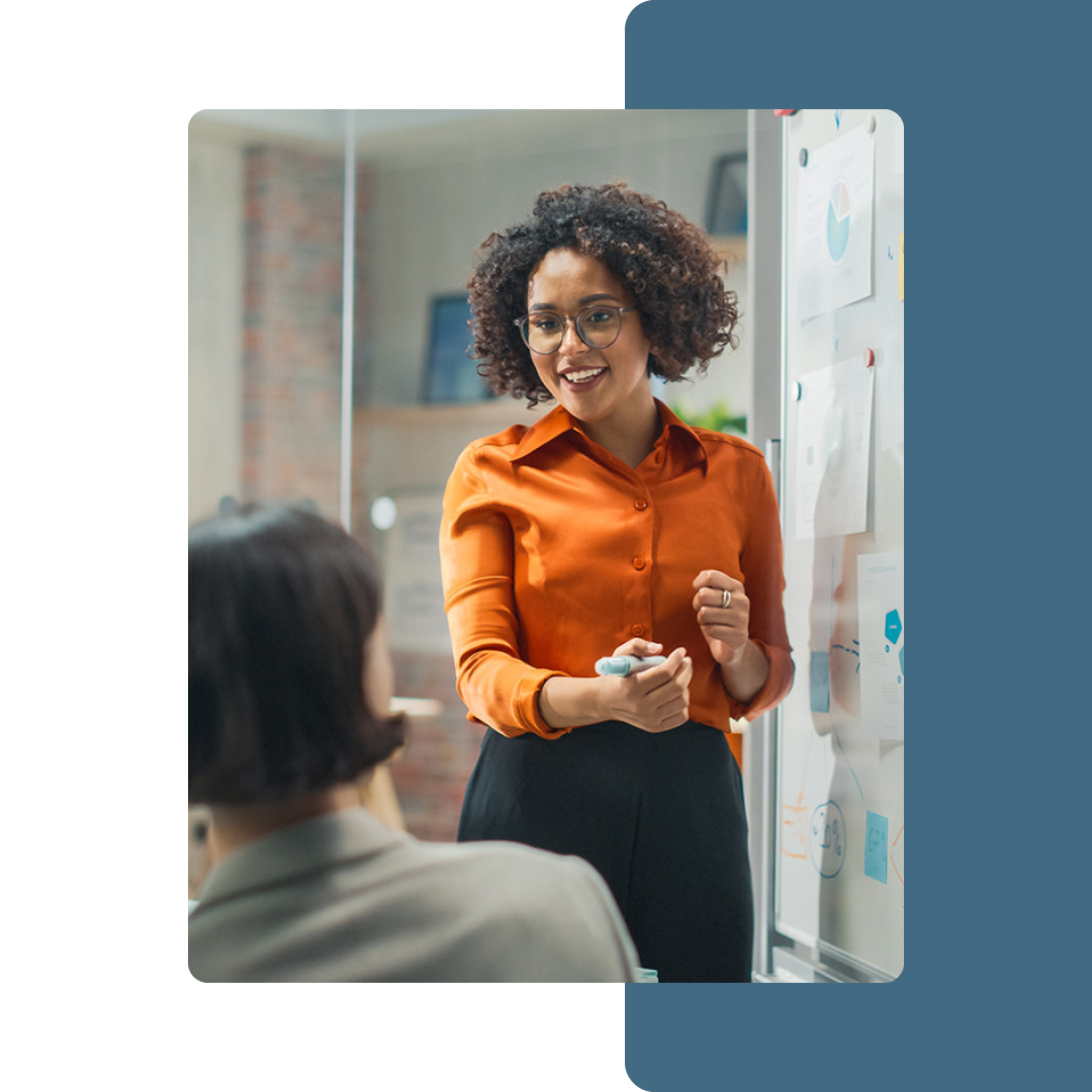 Image of a data professional talking to a group of people and working on a whiteboard