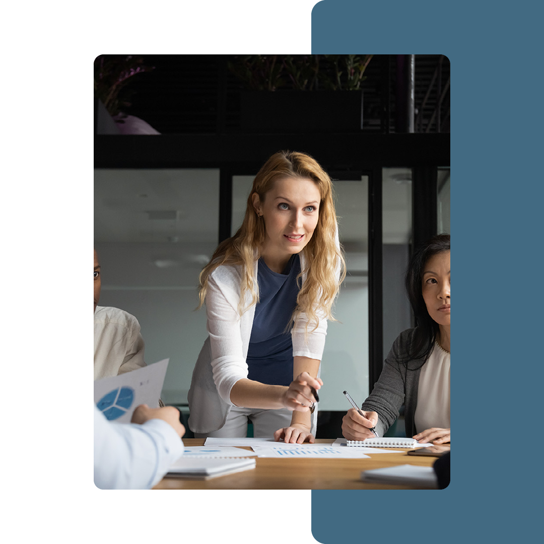 Image of a business person talking to a group of people in a meeting