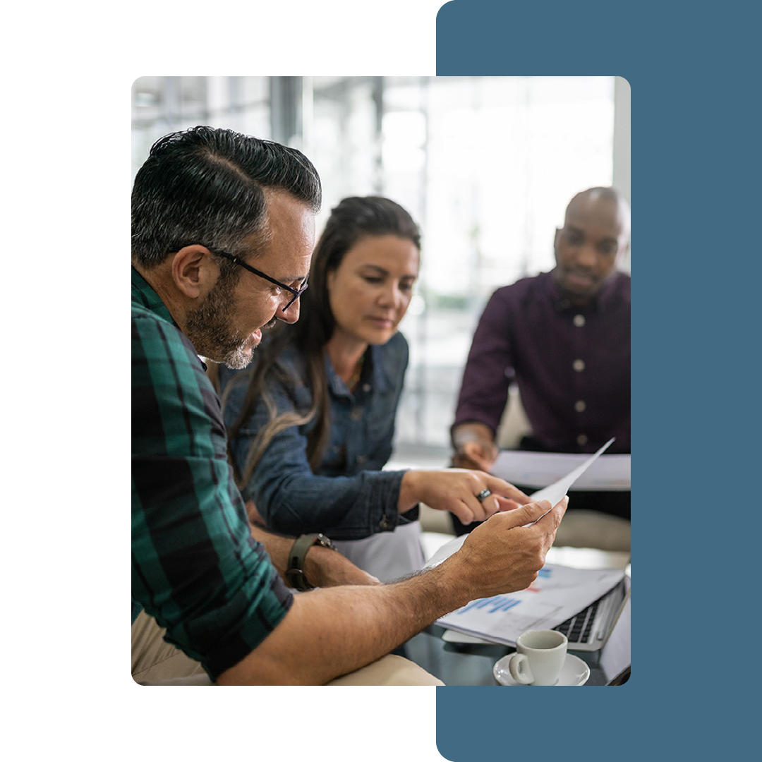 Image of three coworkers discussing contents on a piece of paper