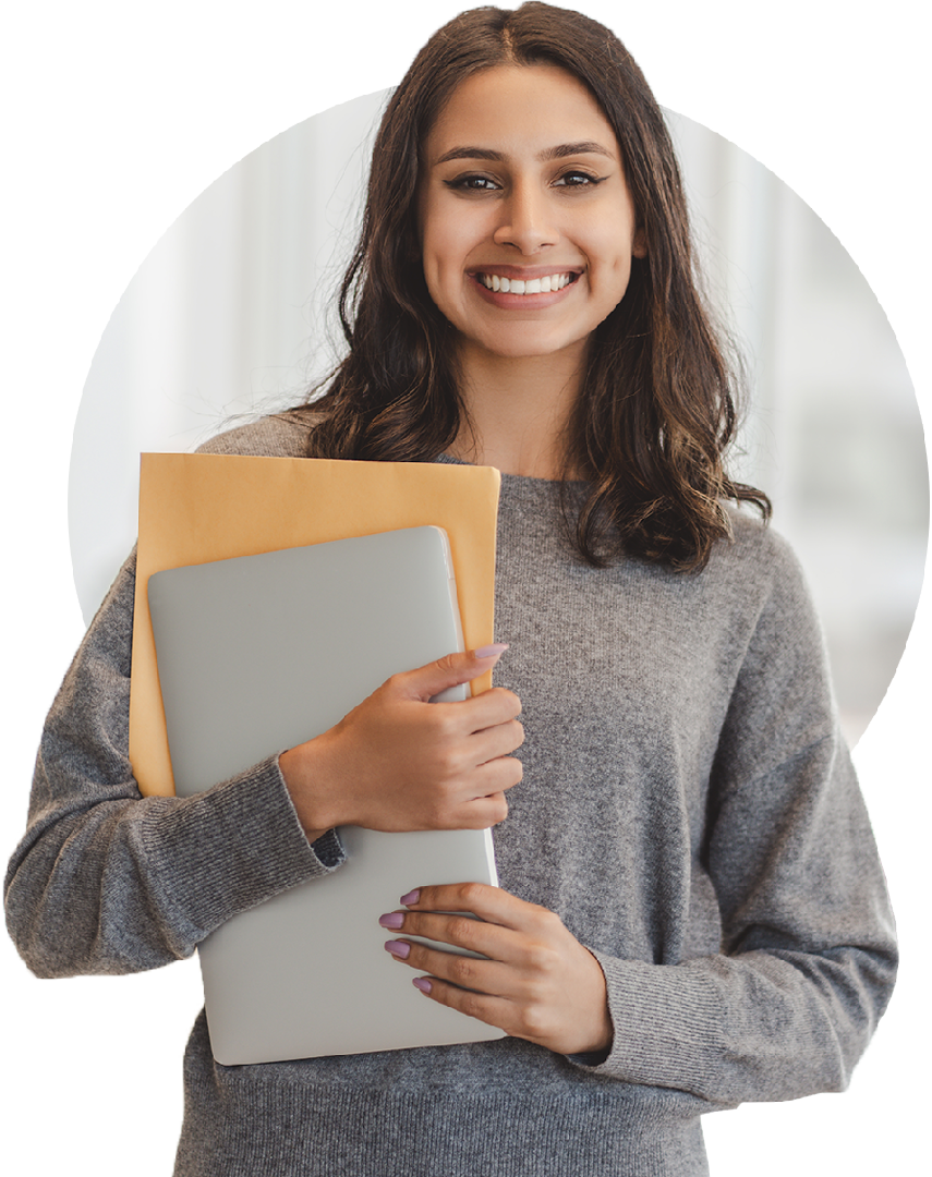 Image of a smiling business person stood holding a laptop