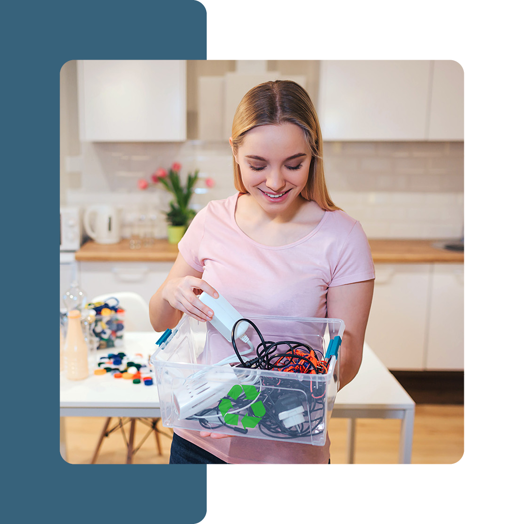 Image of someone holding a box with a recycling symbol containing electronics