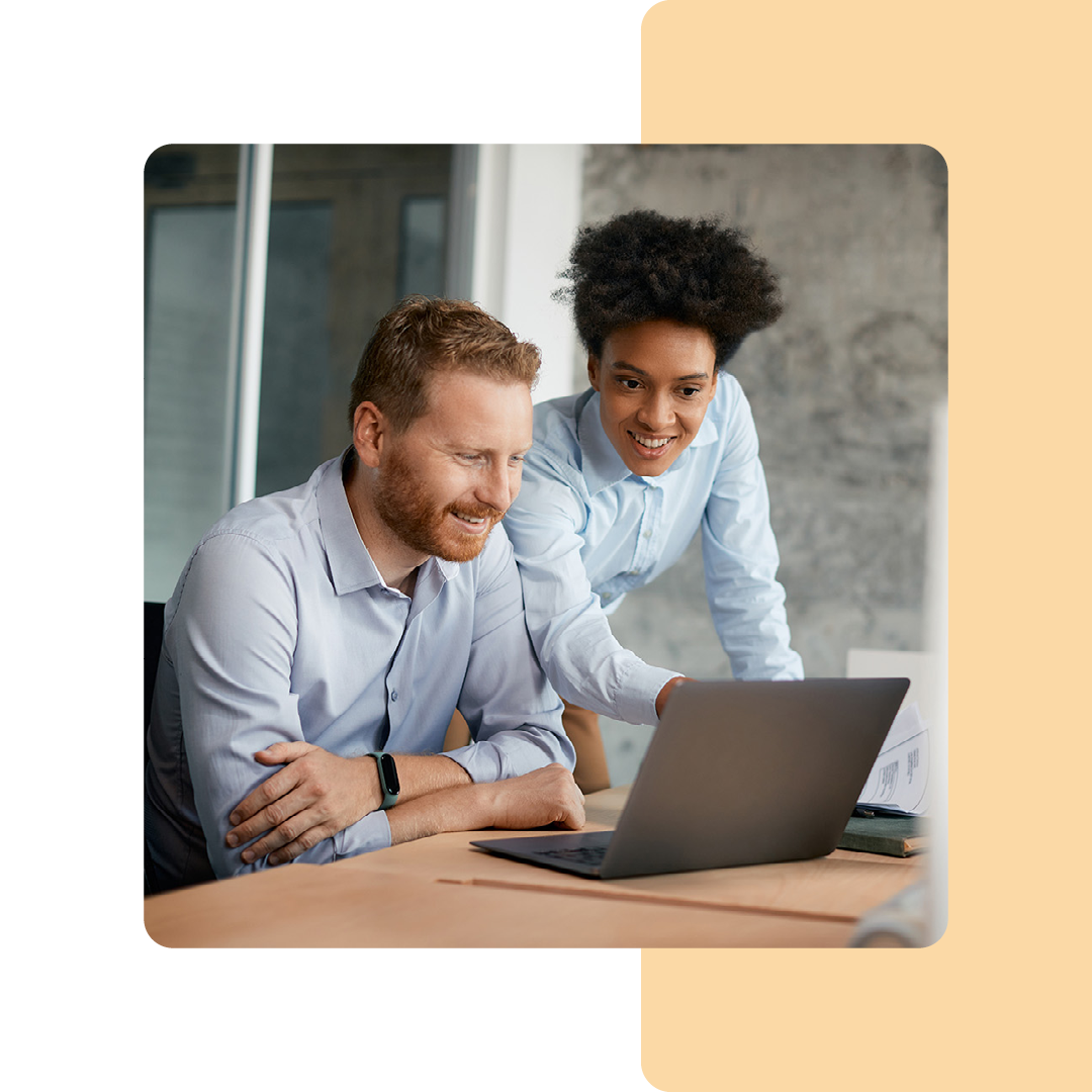 Image of two colleagues working on a laptop together