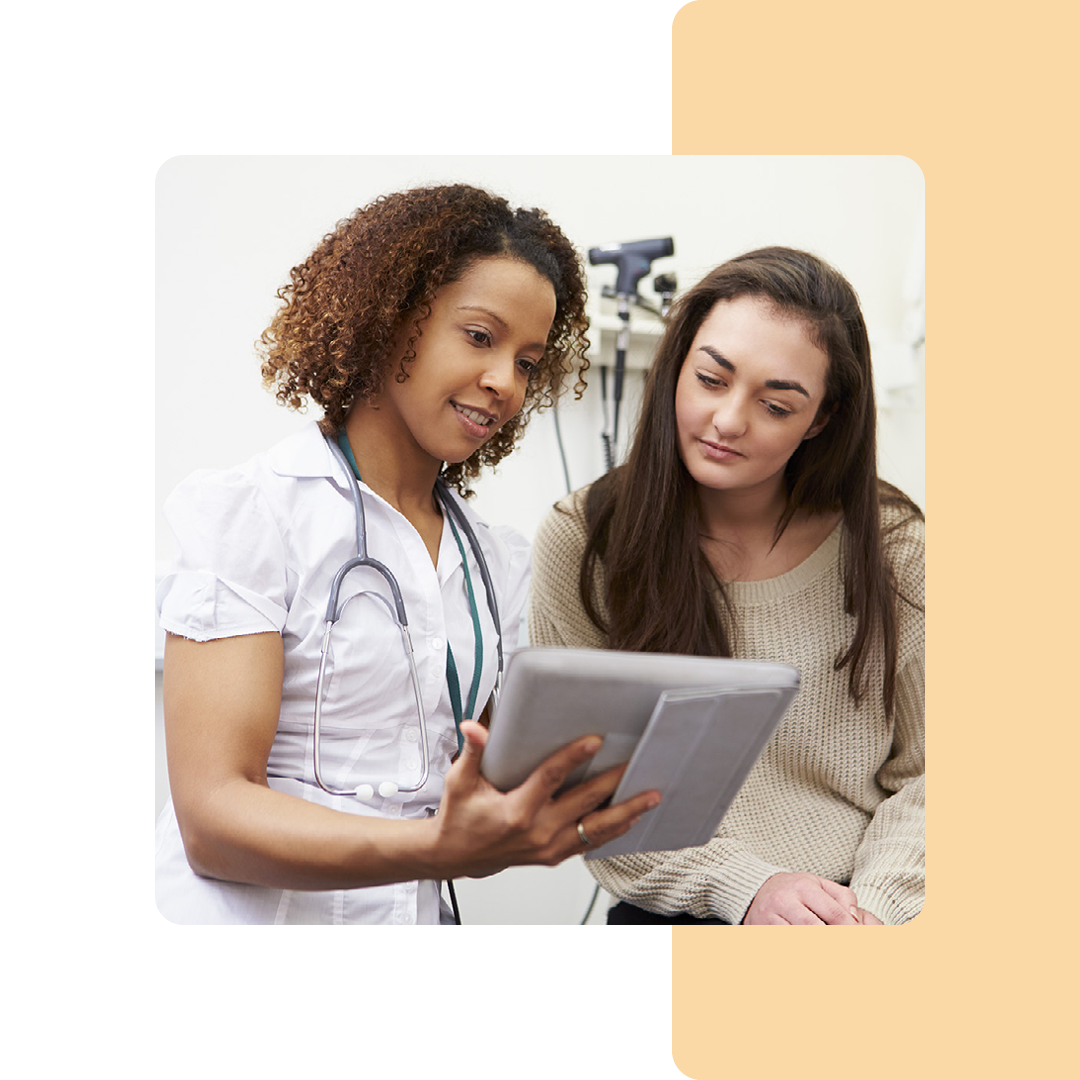 Image of a doctor stood showing a patient information on a tablet