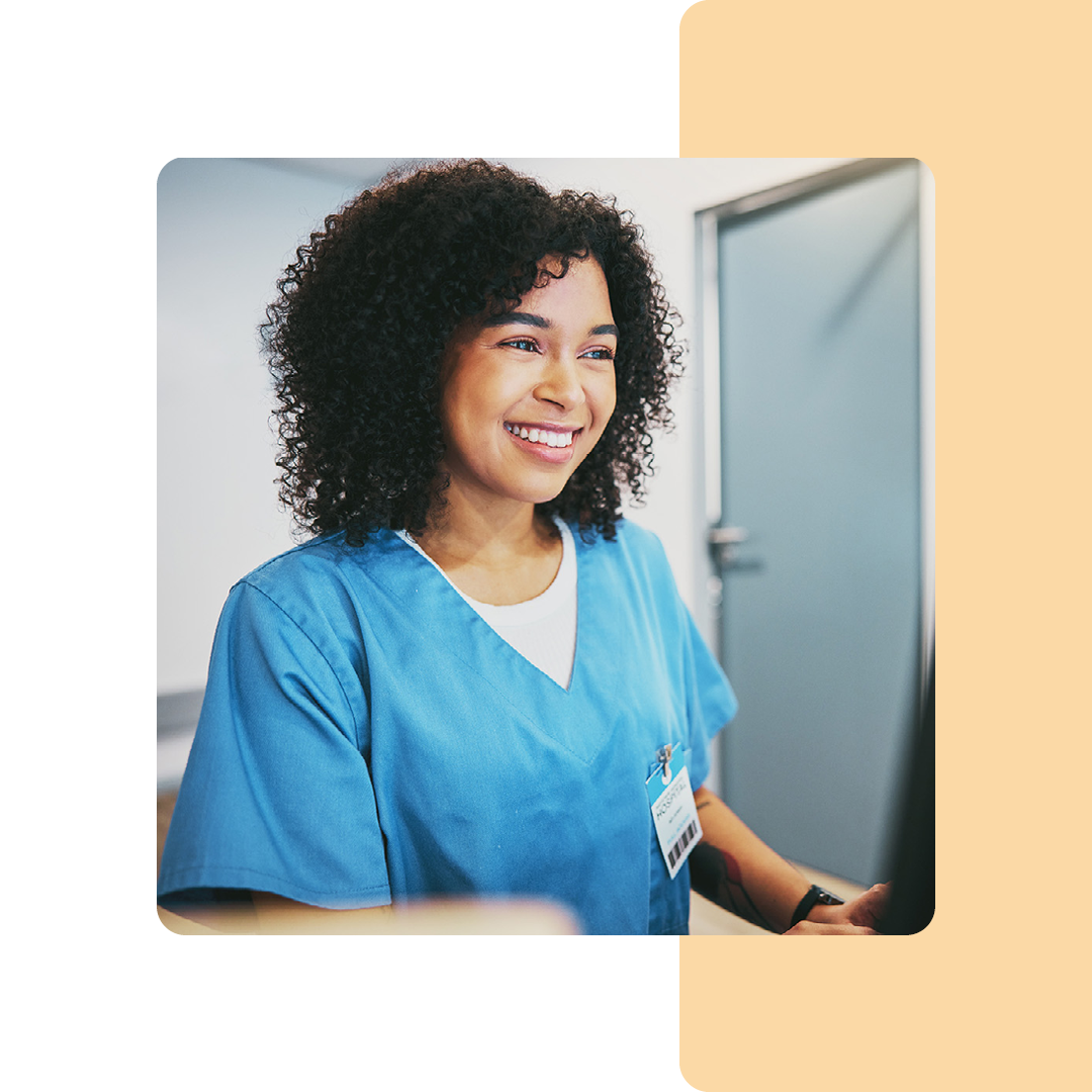 Image of a smiling doctor sat working on a computer