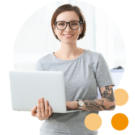 Image of an IT professional stood holding a laptop in an office