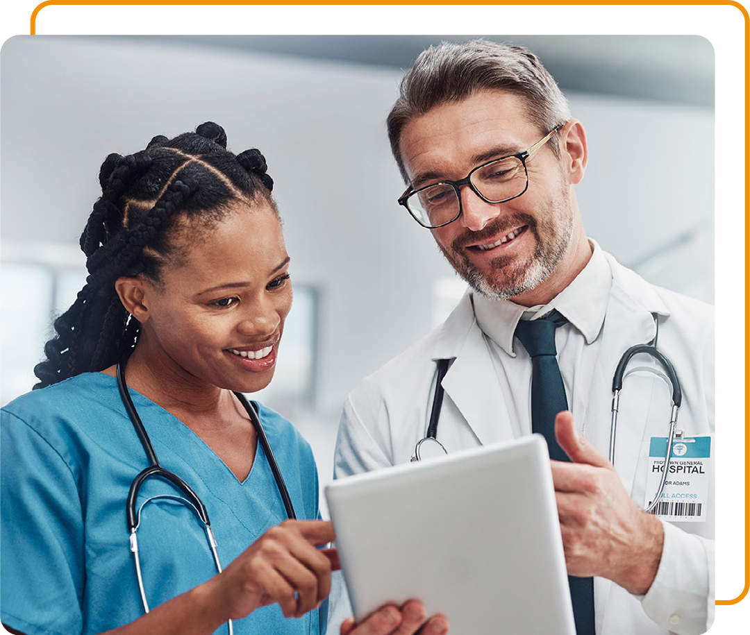 Image of two smiling doctors looking at information on a tablet