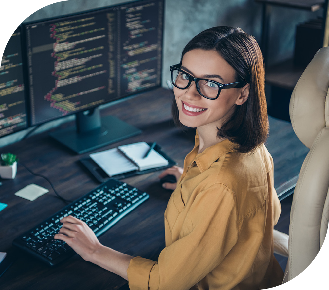 Image of a smiling IT professional working on a computer