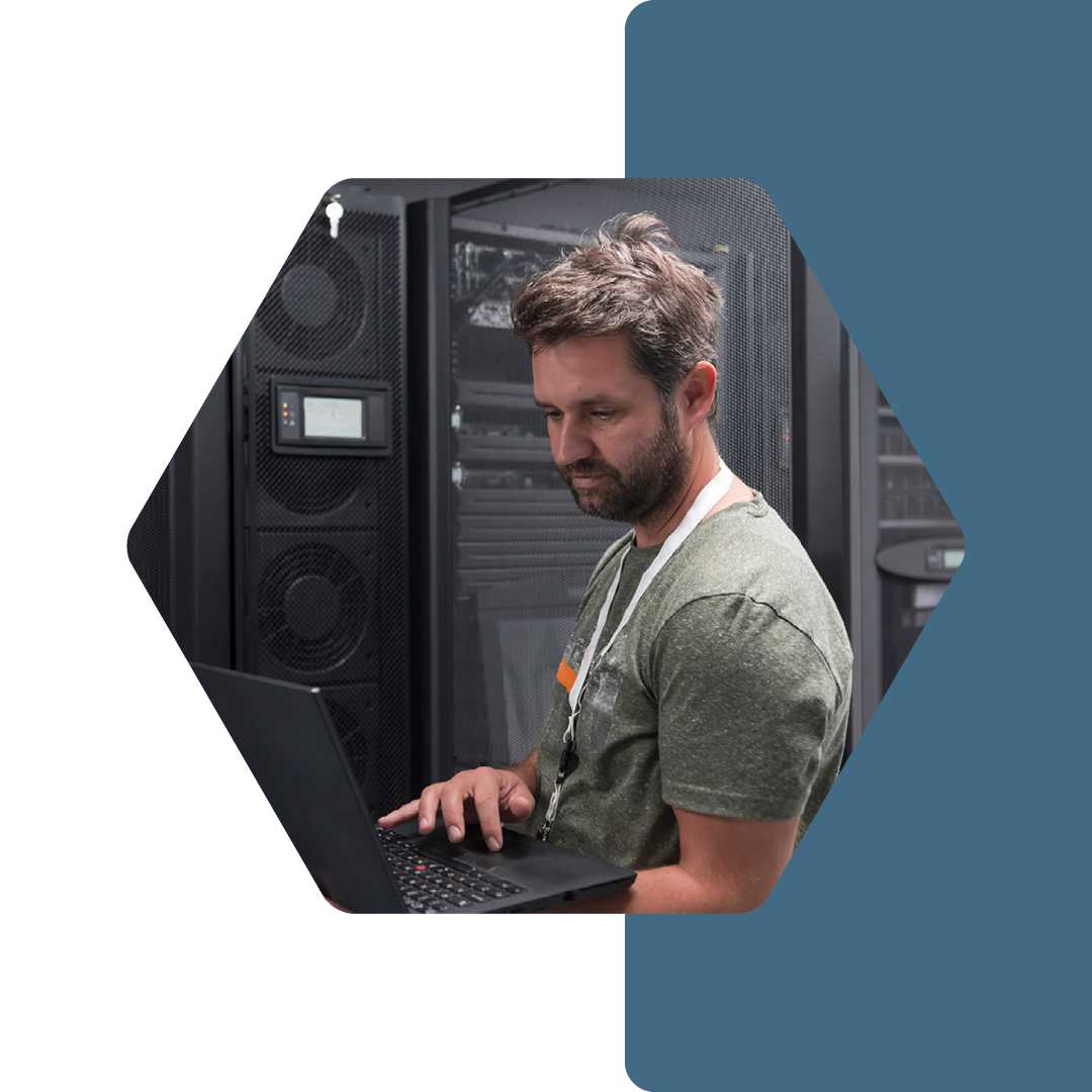 Image of an IT professional working on a laptop in a server room