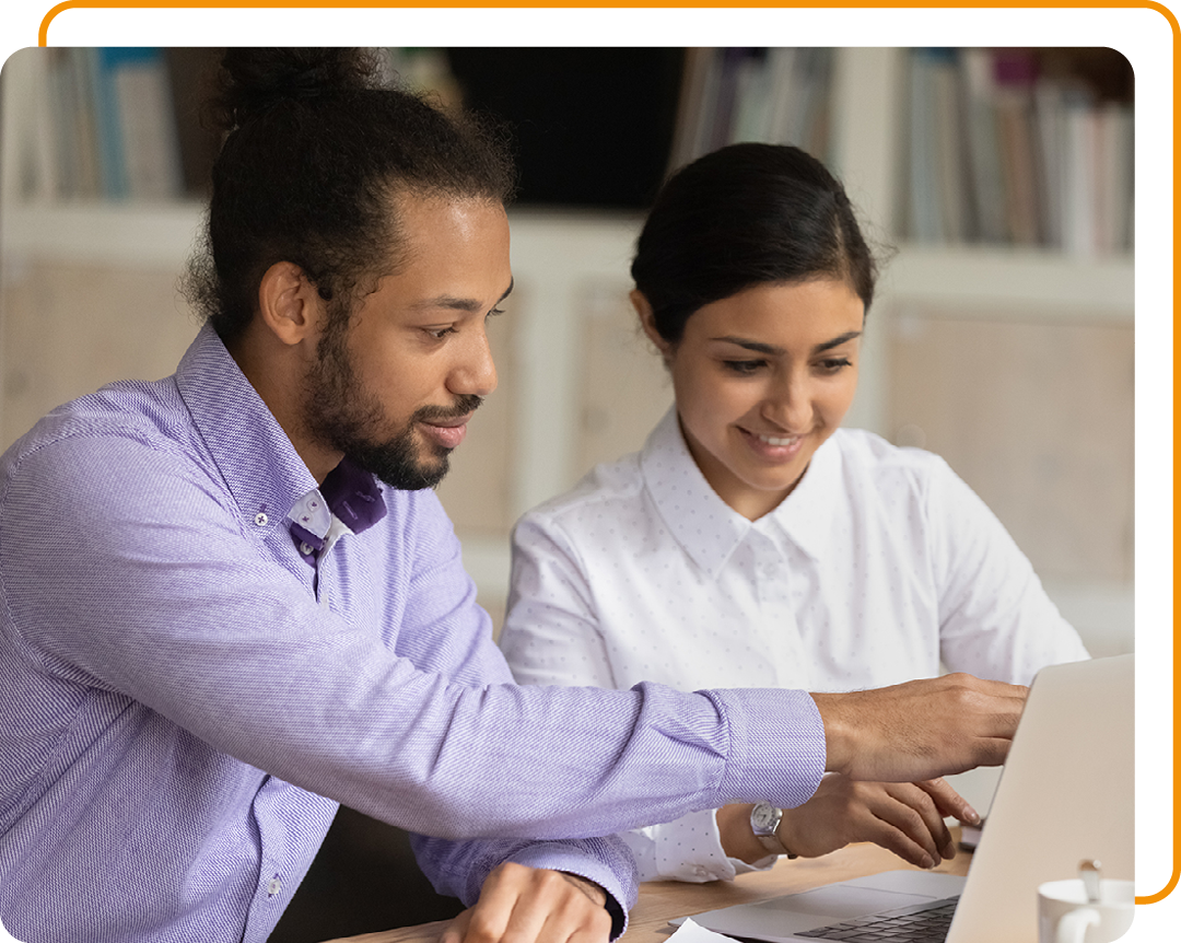 Image of two colleagues working together on a laptop