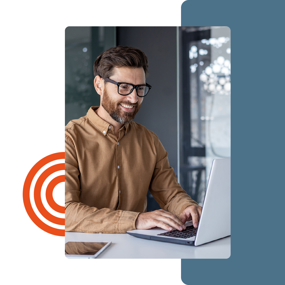 Image of a person smiling while working on a laptop