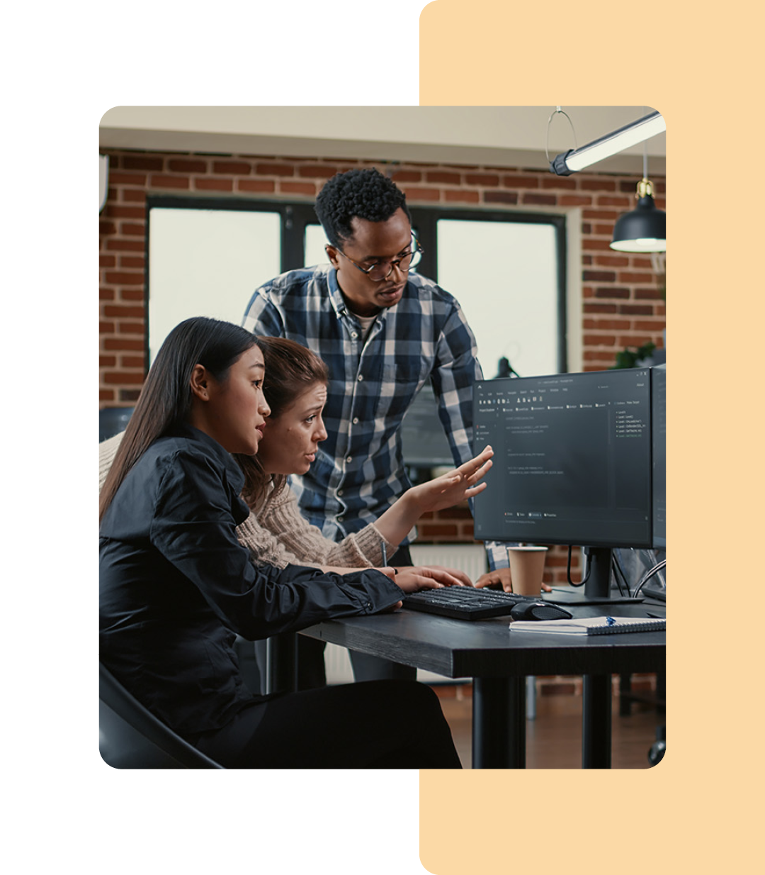 Image of three IT professionals collaborating around a computer