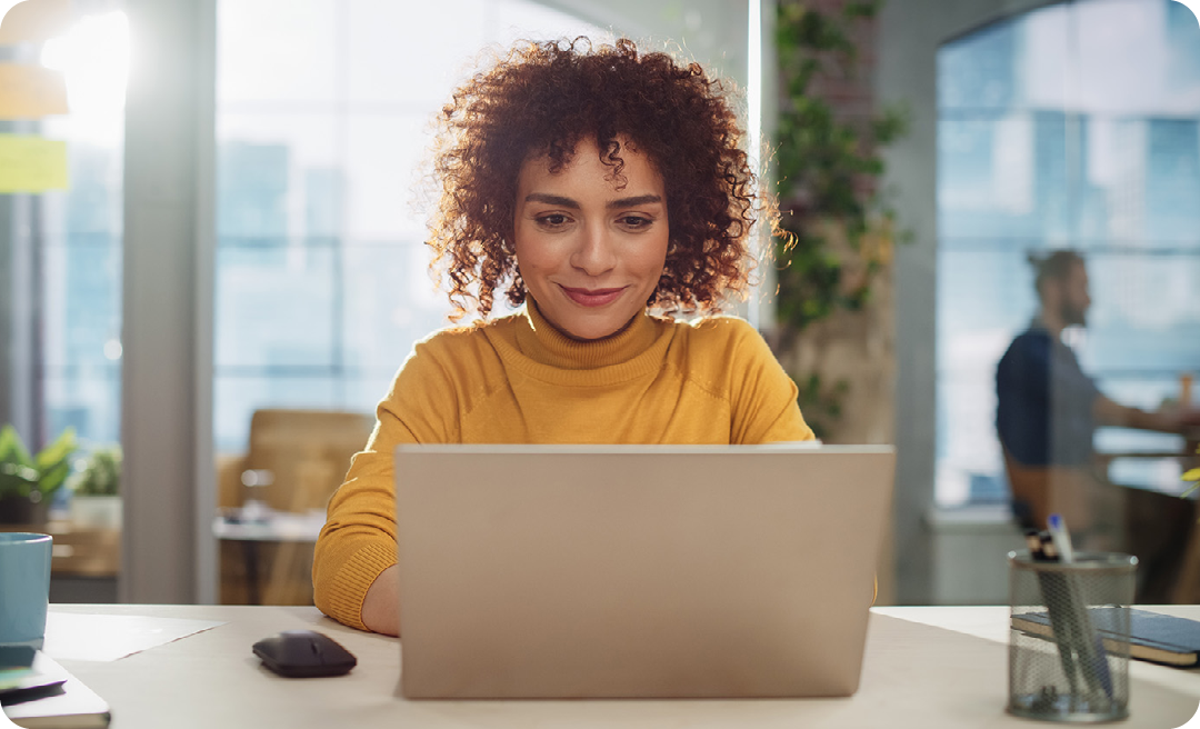 Image of a working professional sat at a laptop