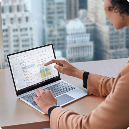 Image of a person using the touchscreen element of a Microsoft Surface laptop