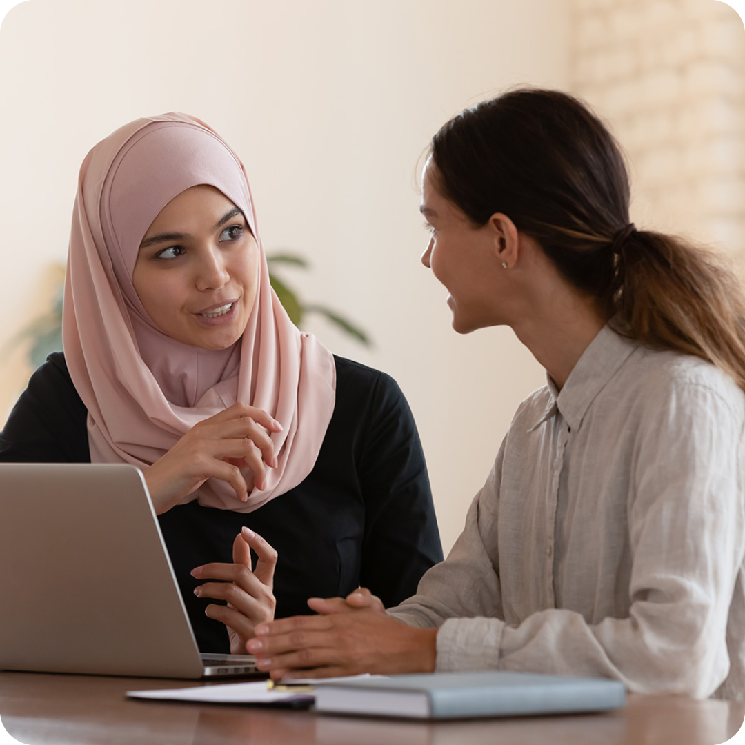 Image of two people working on a laptop