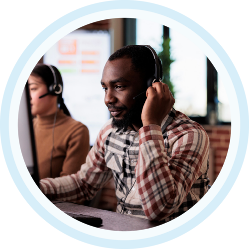 Image of an IT support professional working on a computer with a headset on