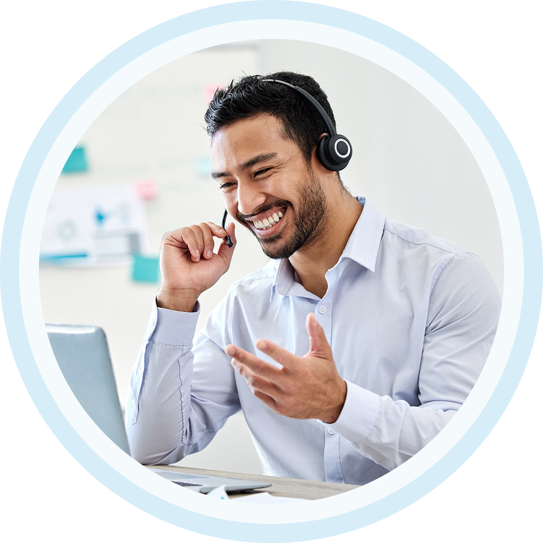 Image of an IT support professional working on a laptop with a headset on