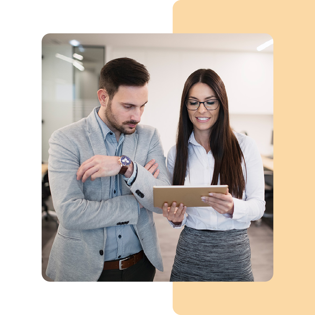 Image of two business colleagues stood working on a tablet