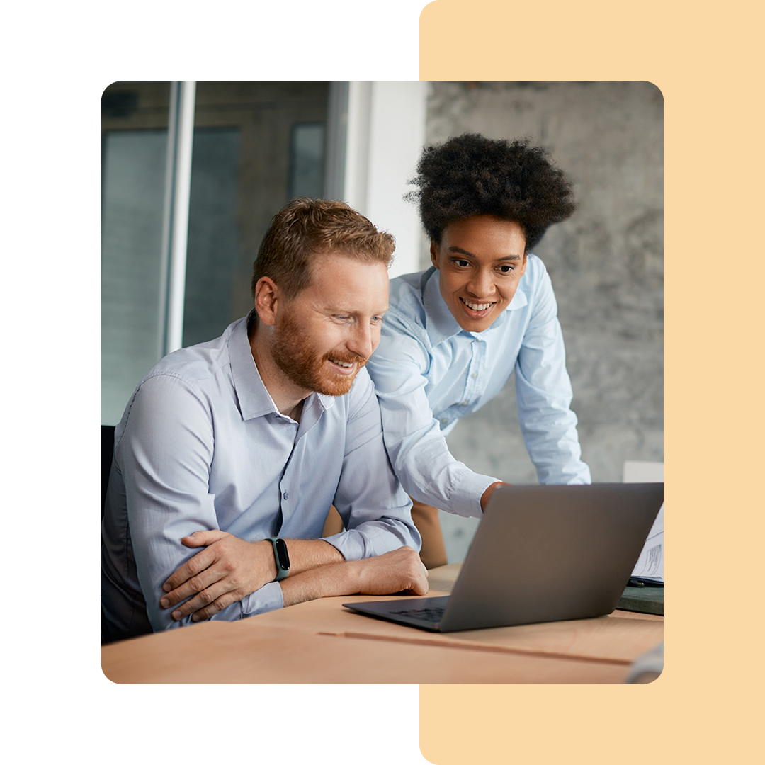 Image of two business professionals working on a laptop together