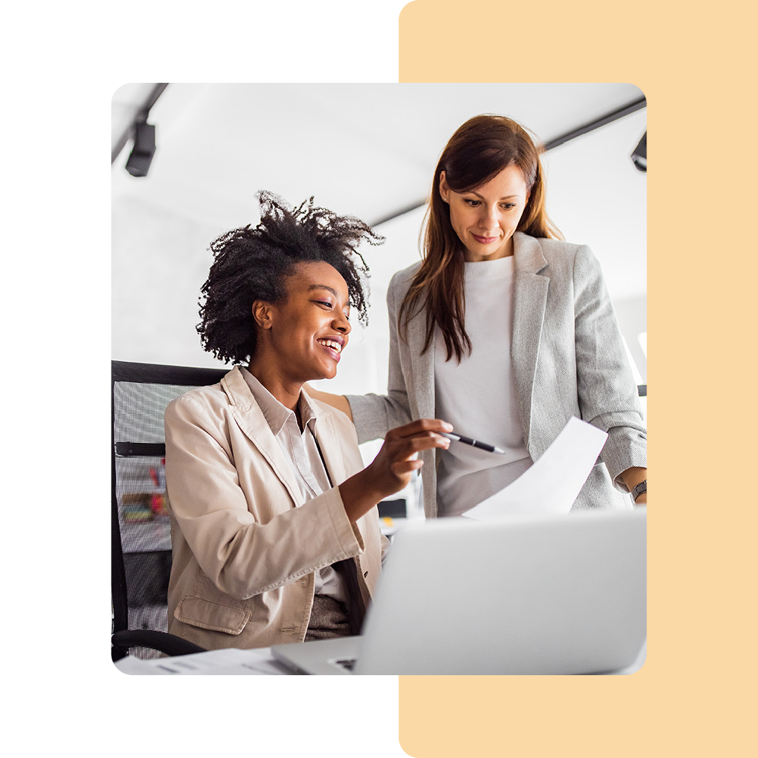 Image of two colleagues working together on a laptop