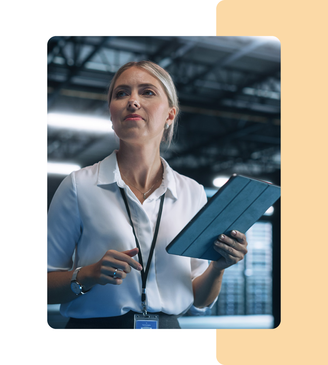 Image of an IT professional walking in a server room holding a tablet