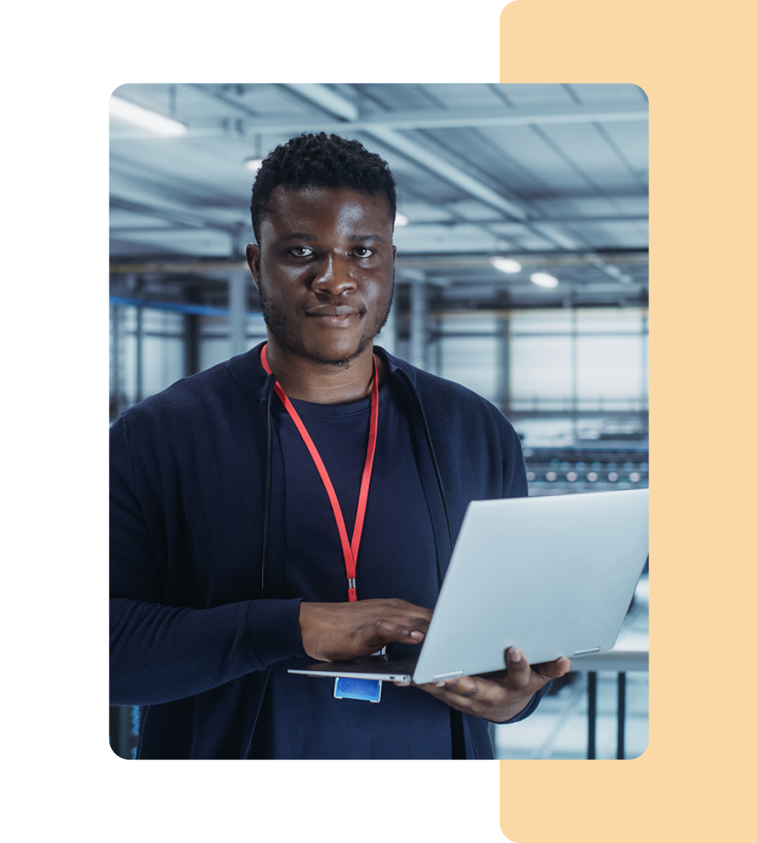 Image of an IT professional walking in a server room holding a laptop