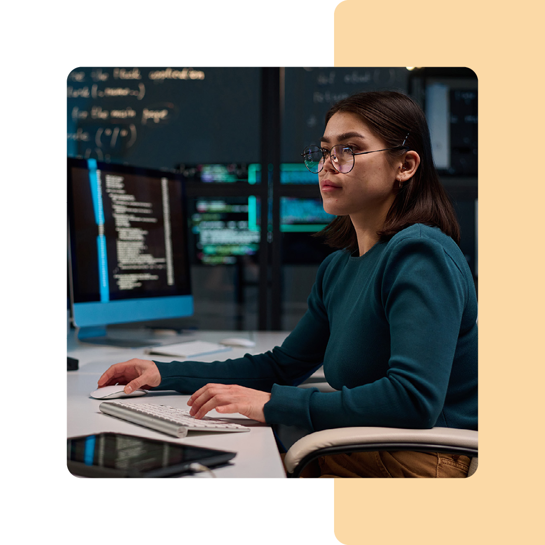 Image of an IT professional sat at a desk working on a computer