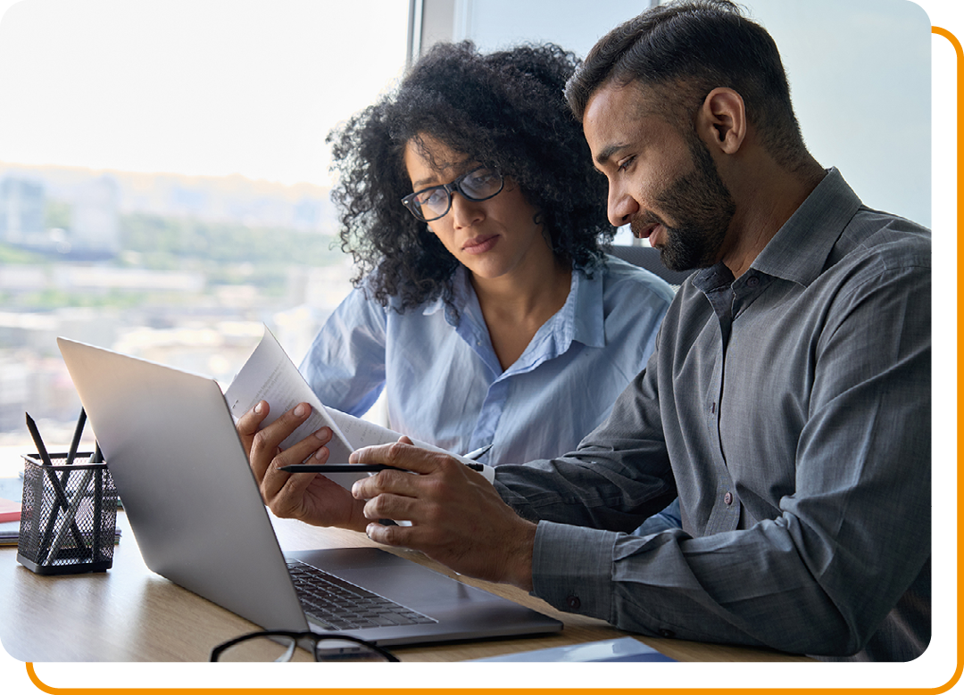 Image of two business professionals working on a laptop together