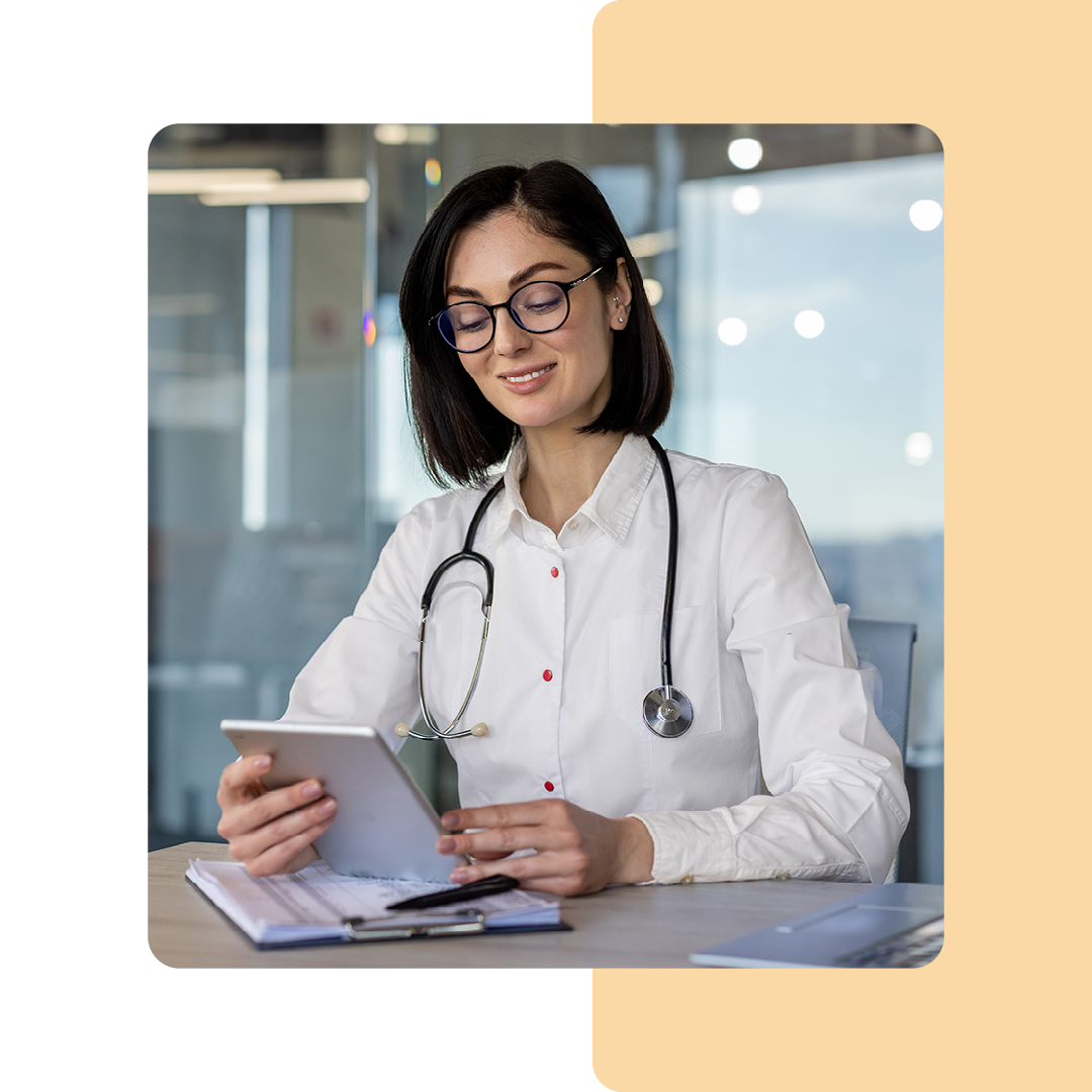 Image of a doctor sat at a desk working on a tablet