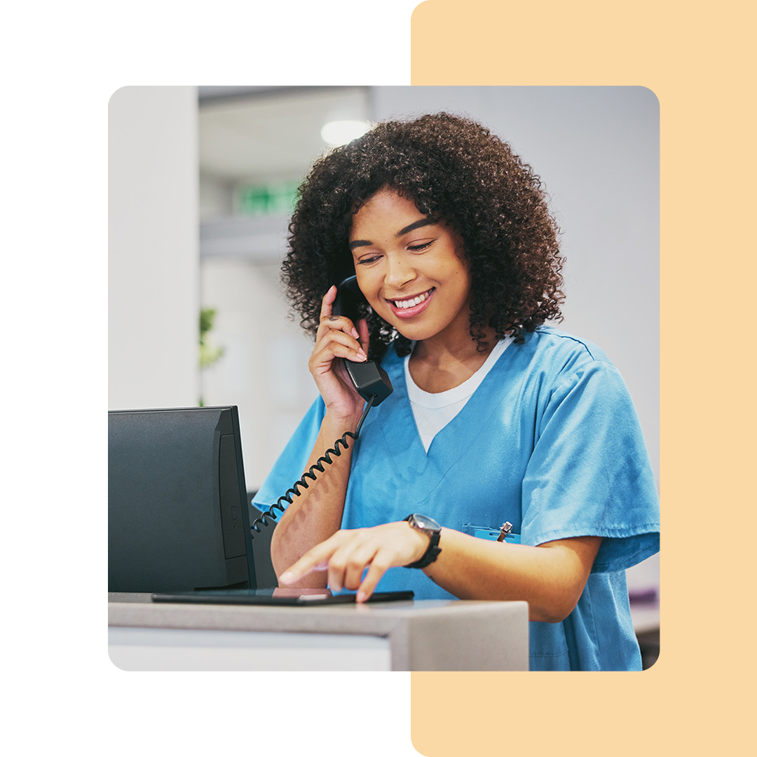 Image of a doctor talking on a phone and working on a tablet