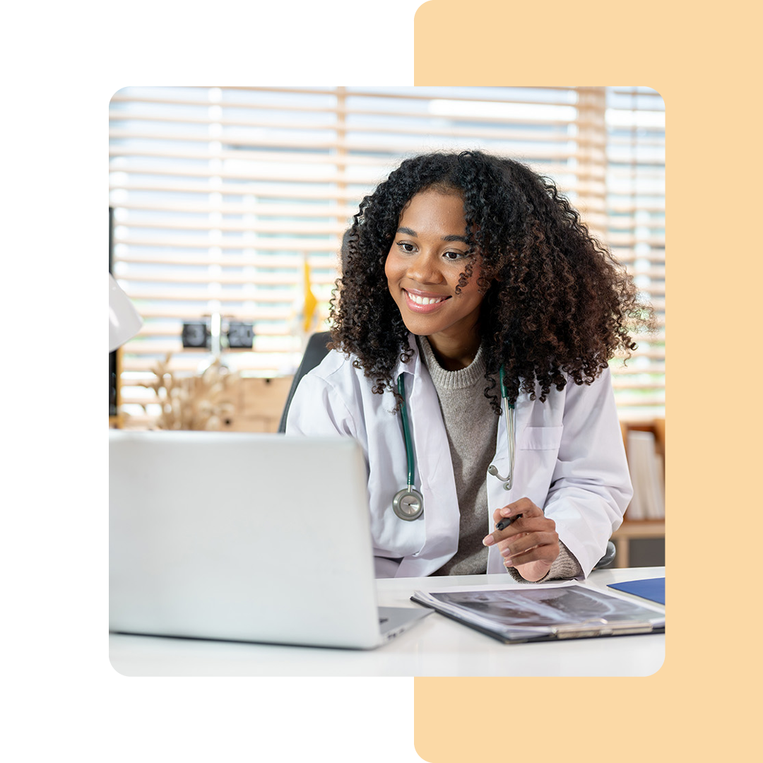 Image of a smiling doctor working on a laptop