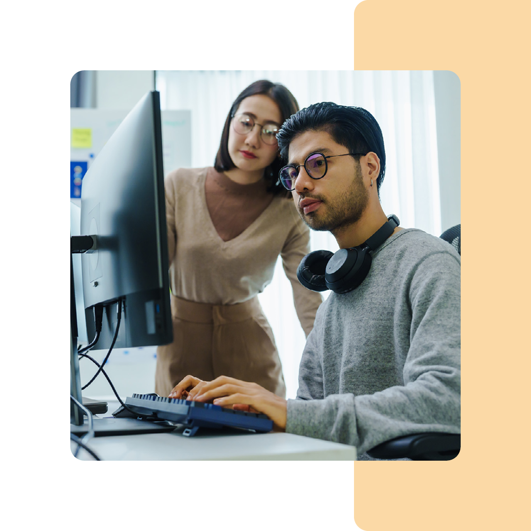 Image of two IT professionals working on a computer together