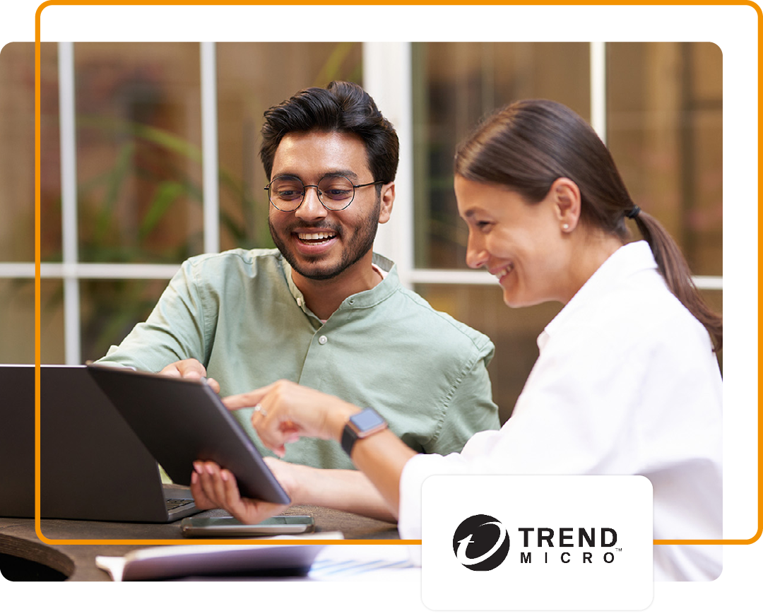 Image of two colleagues conversing while working on a laptop with the Trend Micro logo