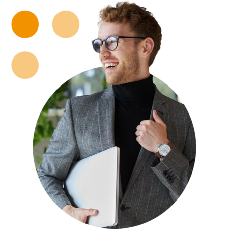 Image of a smiling business professional stood in an office holding a laptop