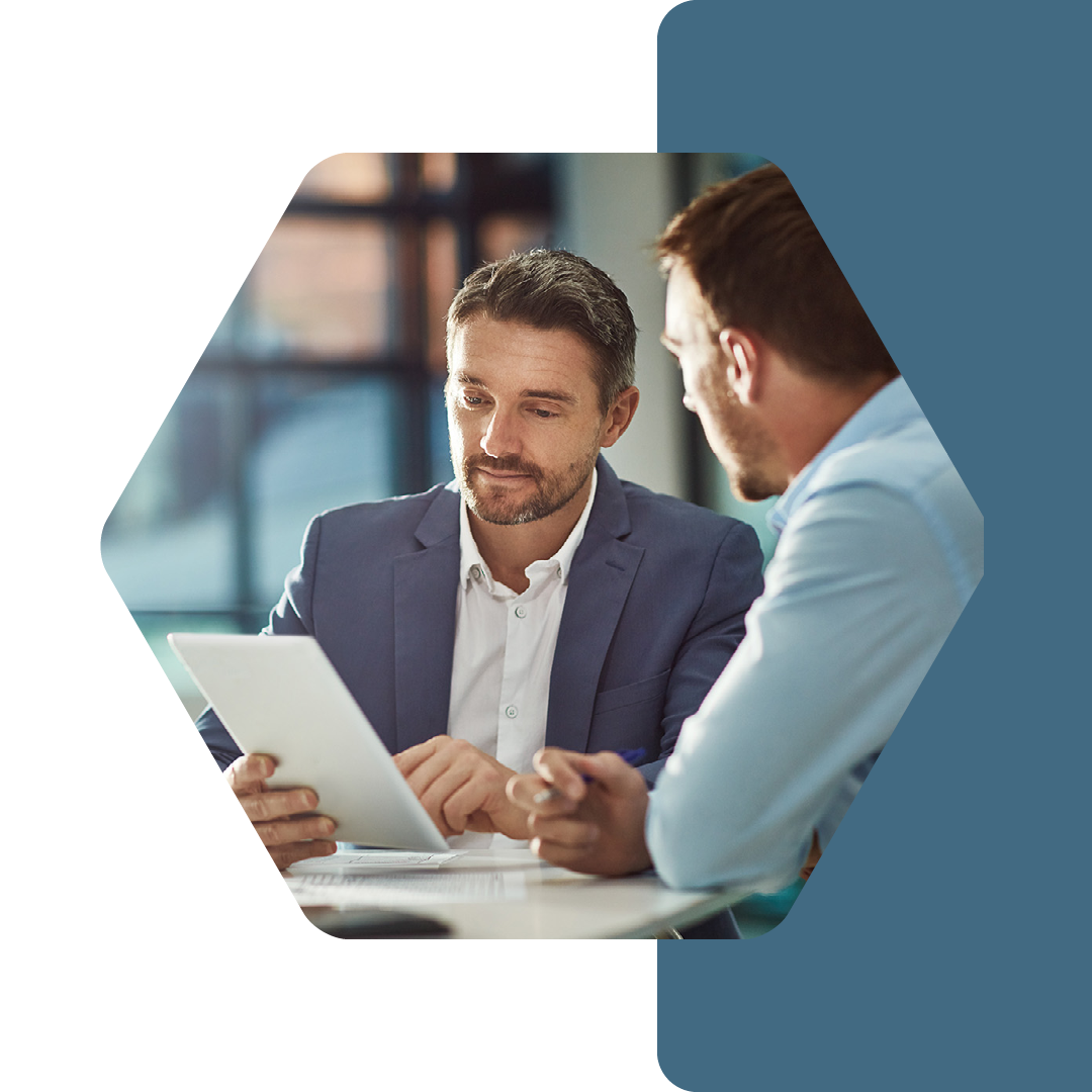 Image of two professionals talking in a meeting and looking at a tablet