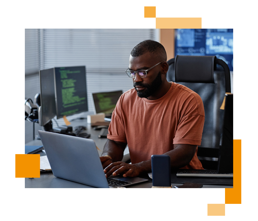 Image of an IT professional working on a laptop at a desk