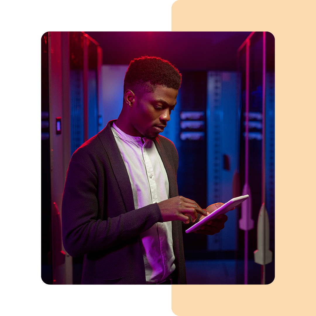 Image of an IT professional working on a tablet in a server room