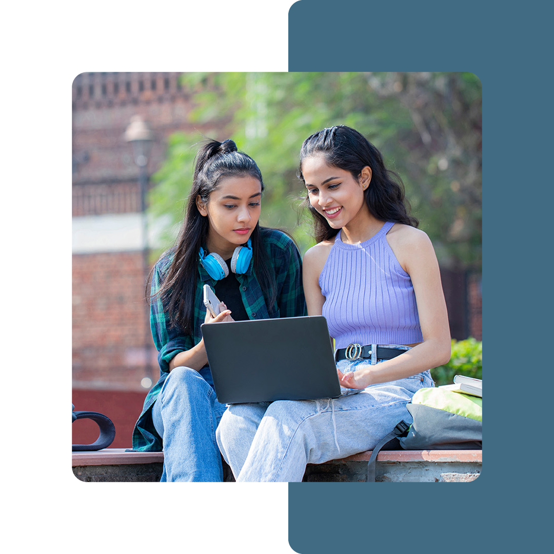 Image of two university students working on a laptop