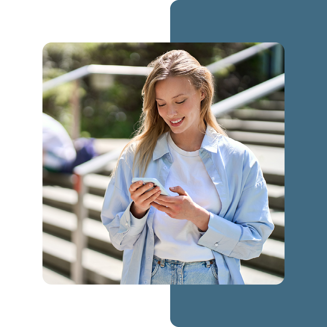 Image of a university student stood on a mobile phone on campus