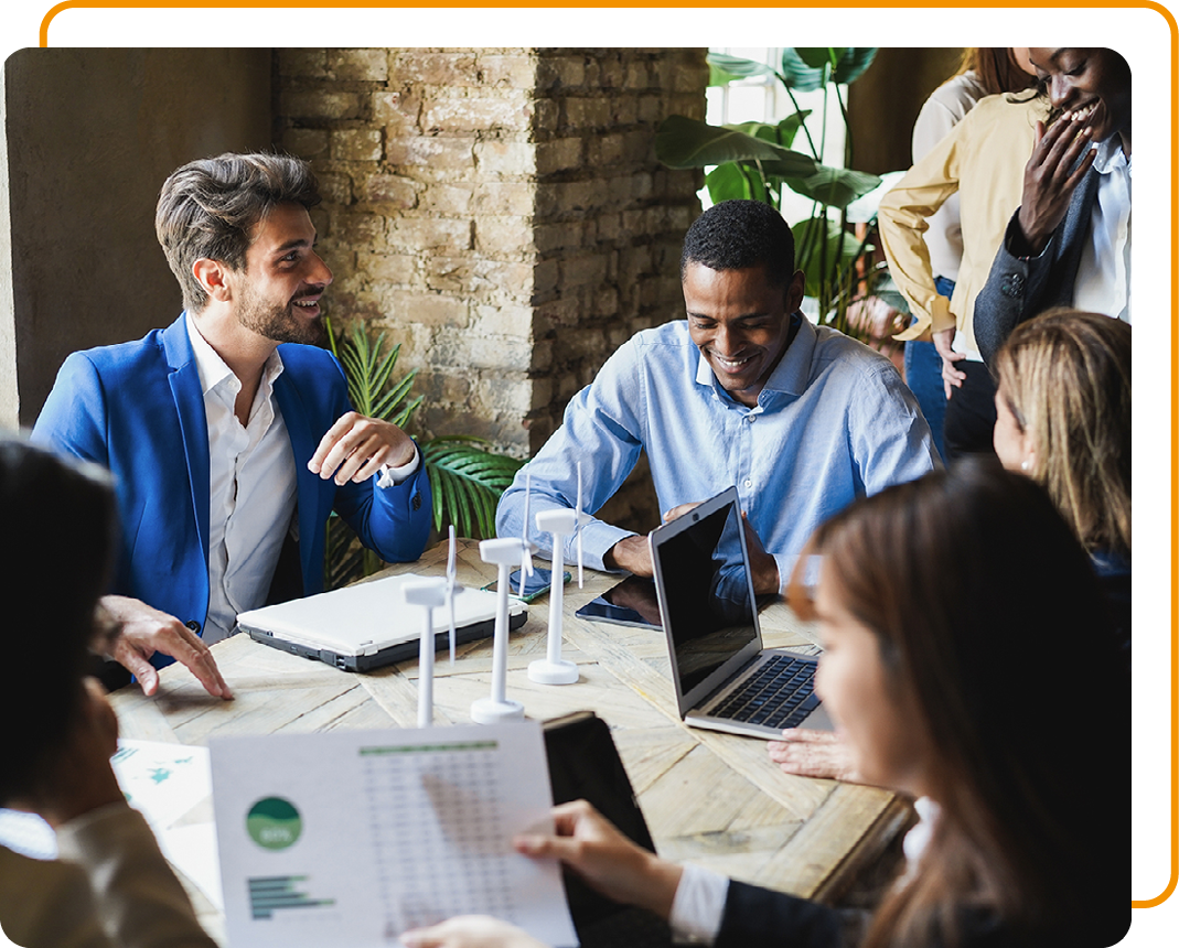 Image of a group of people in a meeting with model wind turbines on a table